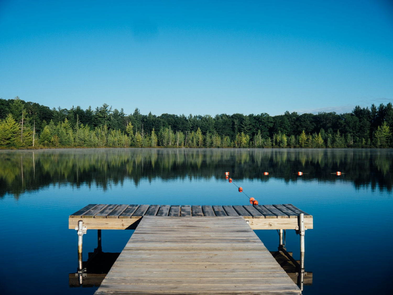 Lake with a wooden dock at calm morning